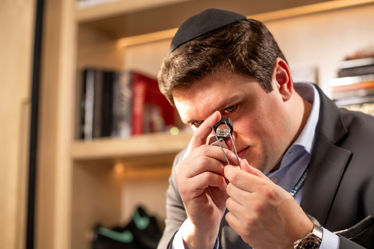 A man is observing diamonds with a magnifying lens