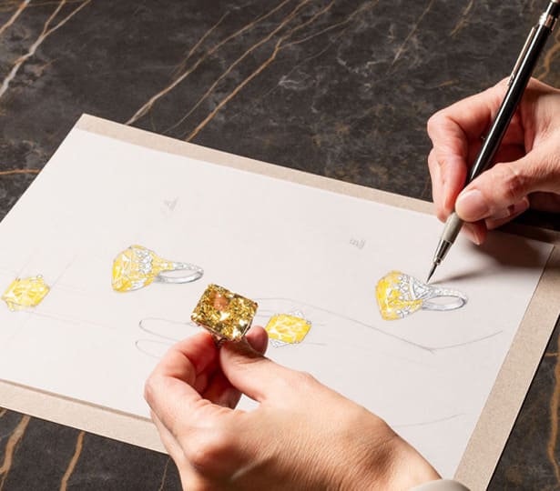 A woman is holding an amber colored diamond