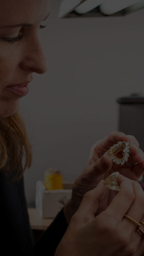 A woman is holding up two beautiful diamond rings