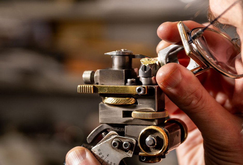 A man is looking at a diamond through a magnifying lense