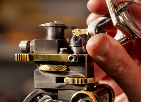 A man is looking at a diamond through a magnifying lense