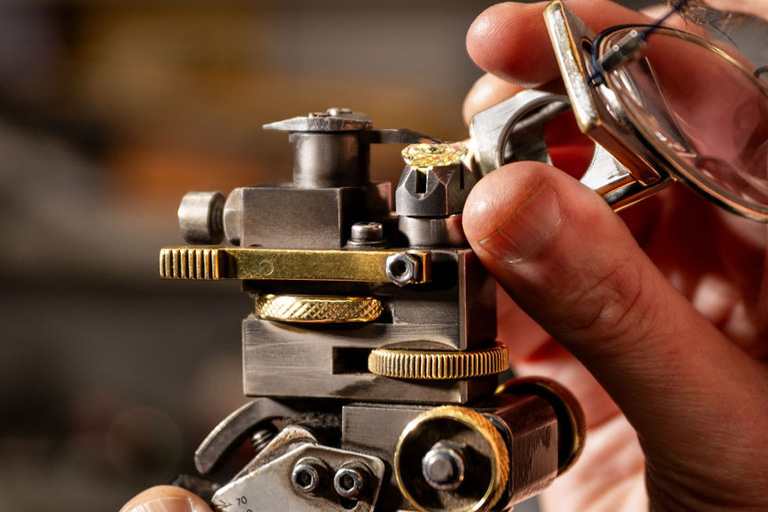 A man is looking at a diamond through a magnifying lense